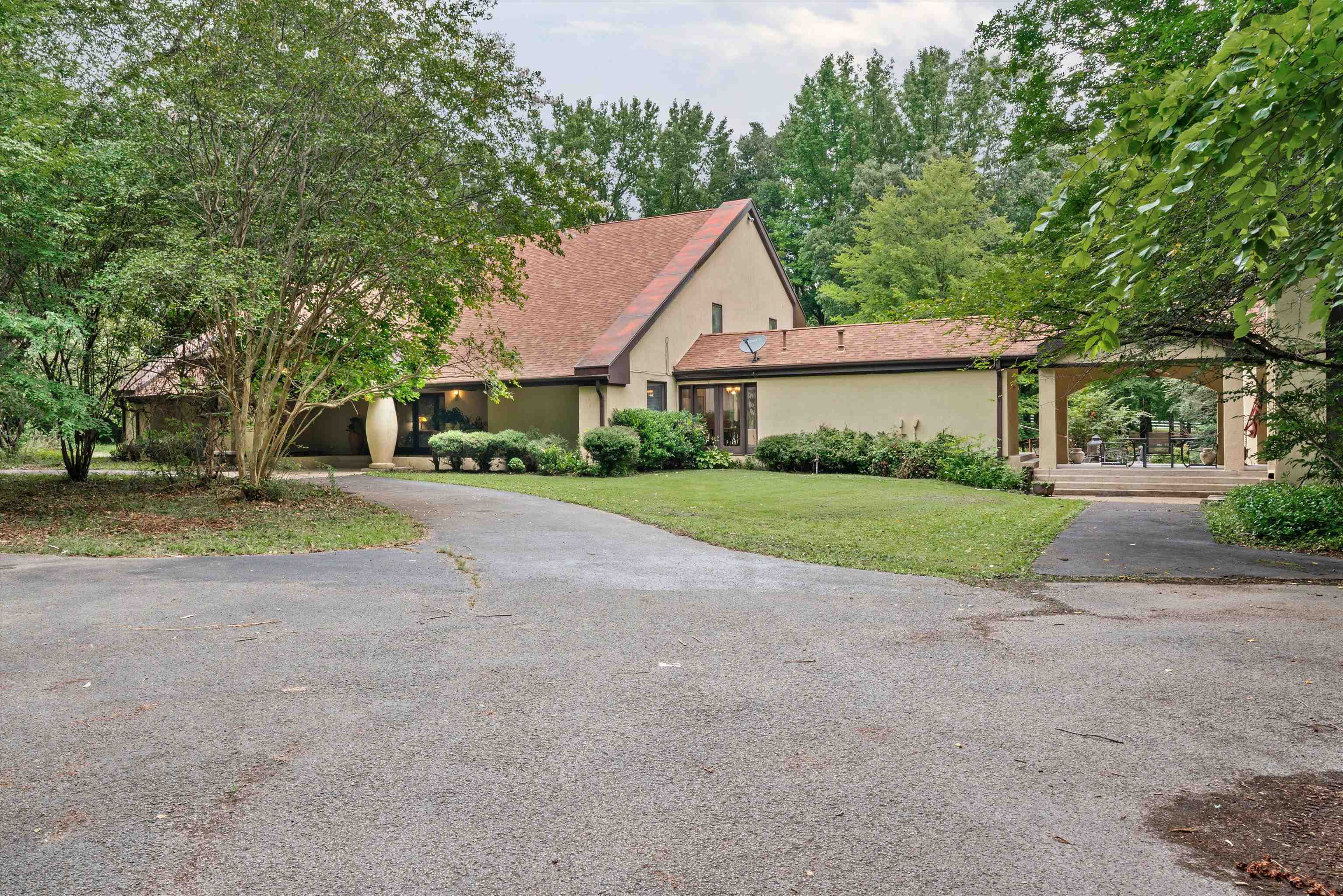 a view of a house with a big yard and large trees