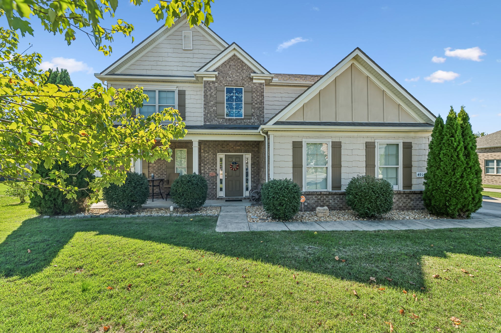 a front view of a house with yard and green space