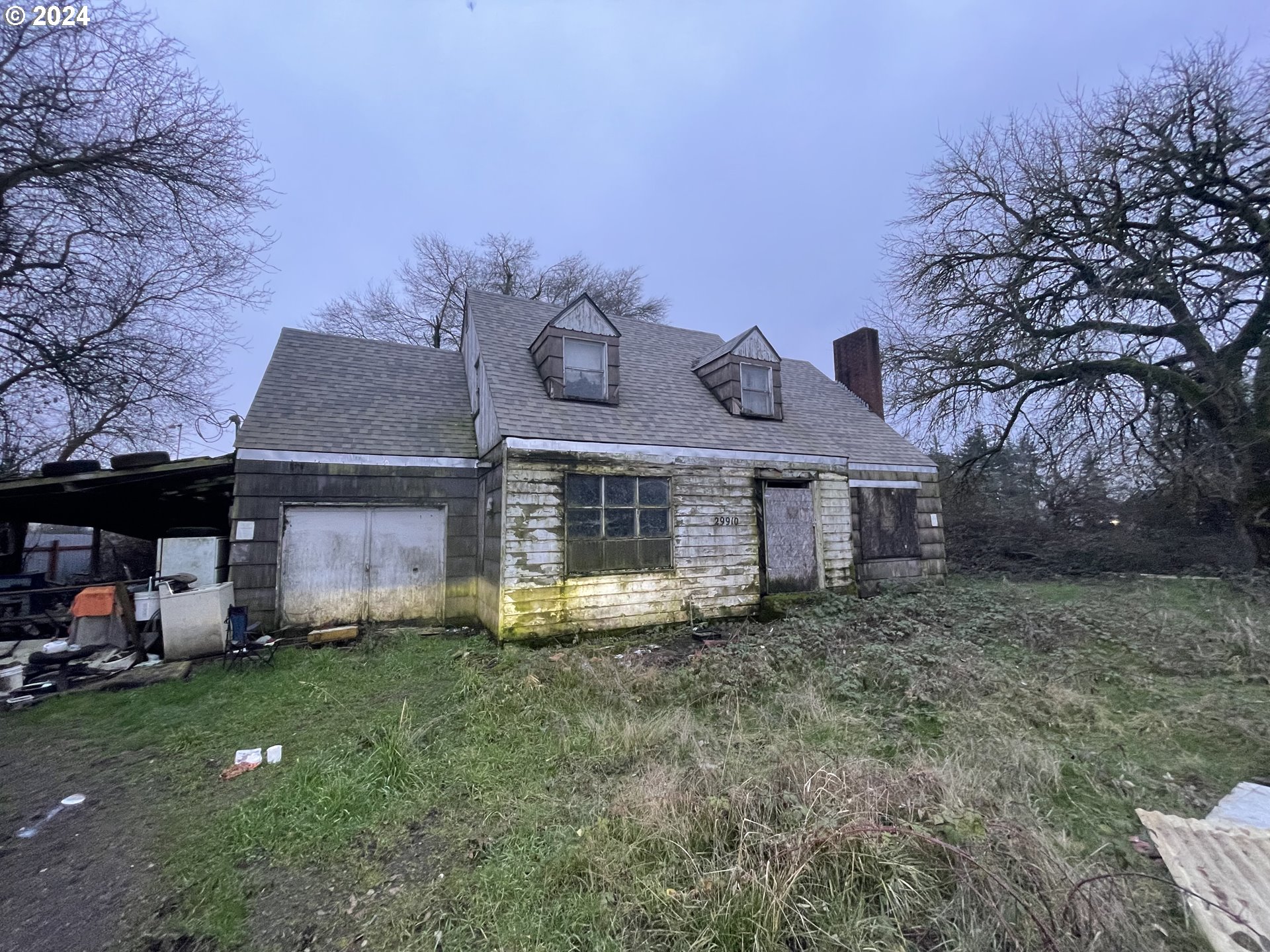 a front view of house with yard and trees in the background