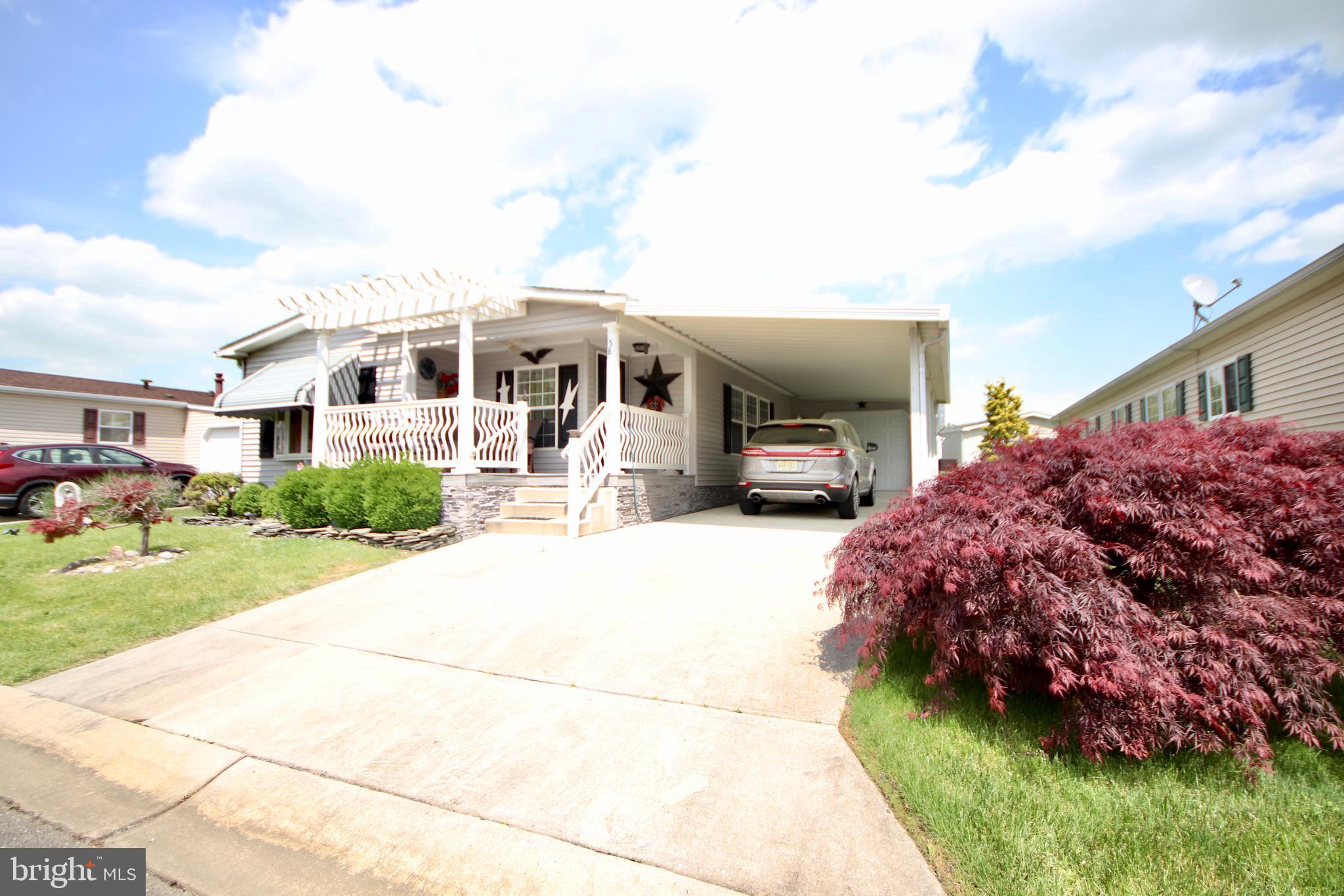 a front view of a house with a garden and parking