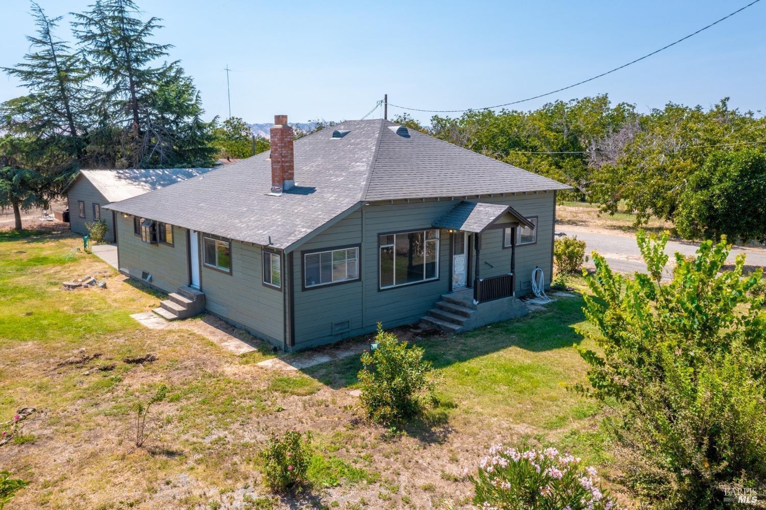 a aerial view of a house with table and chair under an umbrella