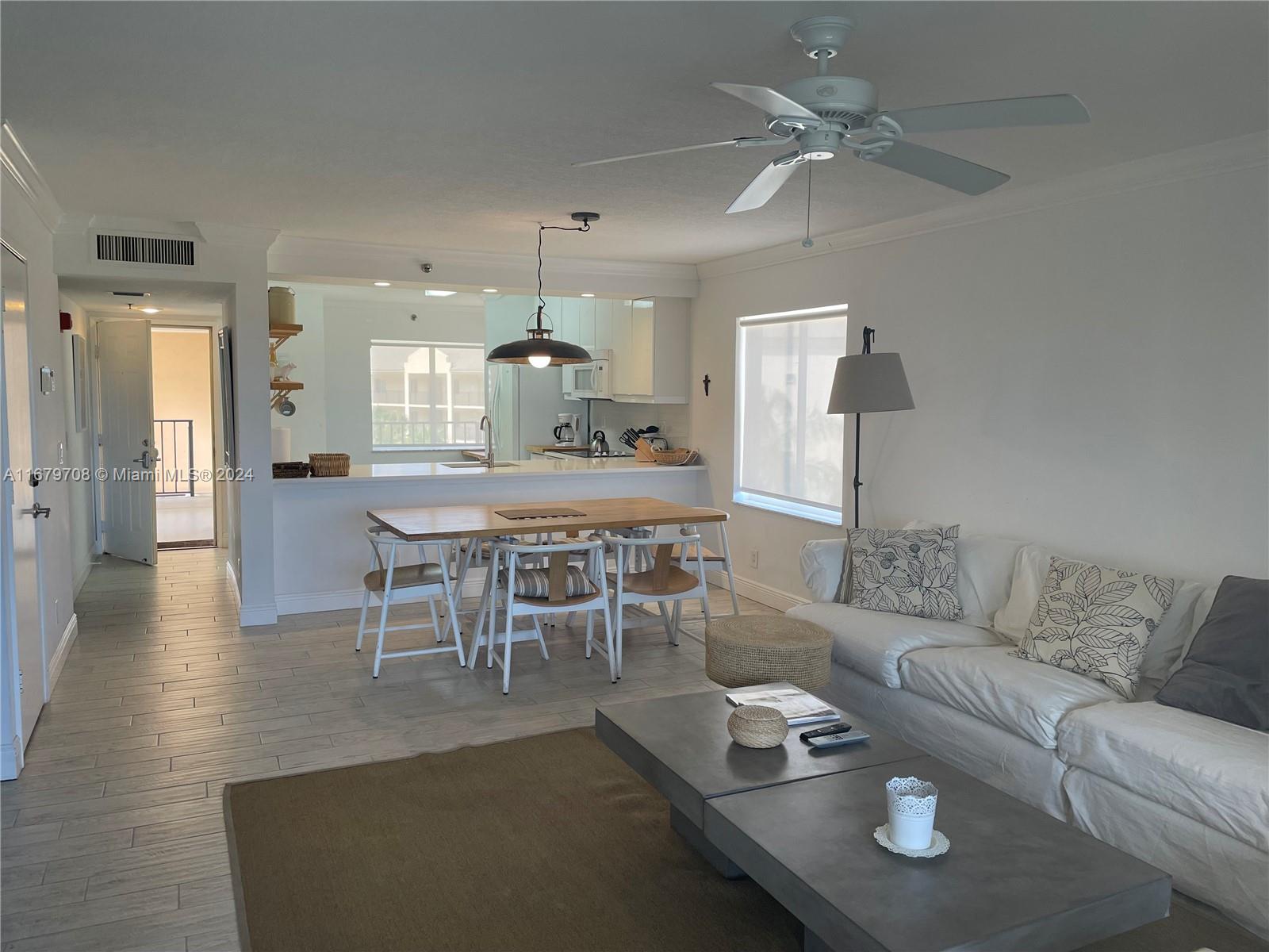 a living room with furniture and a dining table with kitchen view