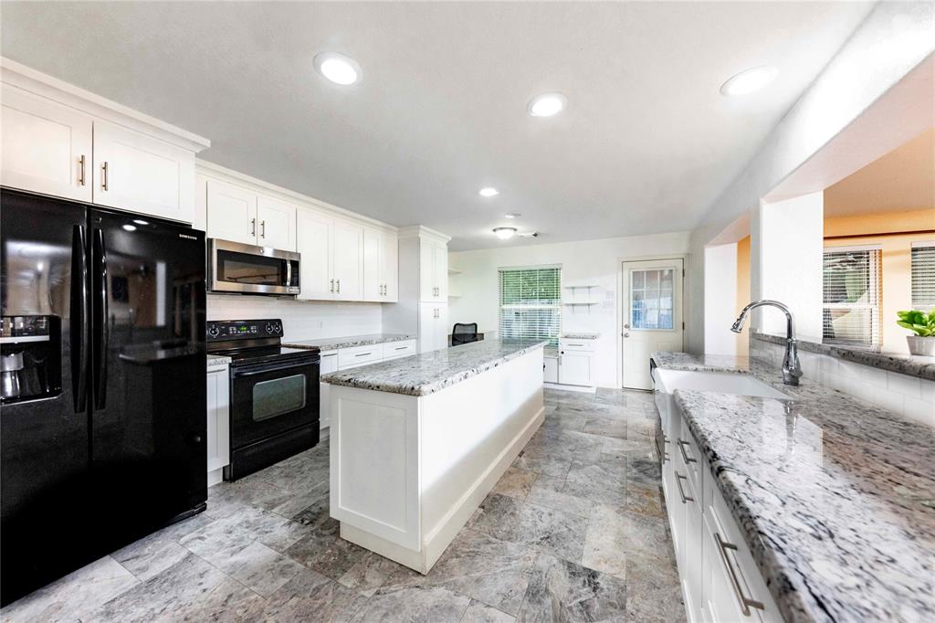 a large kitchen with stainless steel appliances lots of counter space and wooden floor