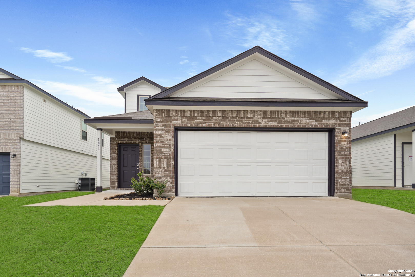 a front view of a house with a yard and garage