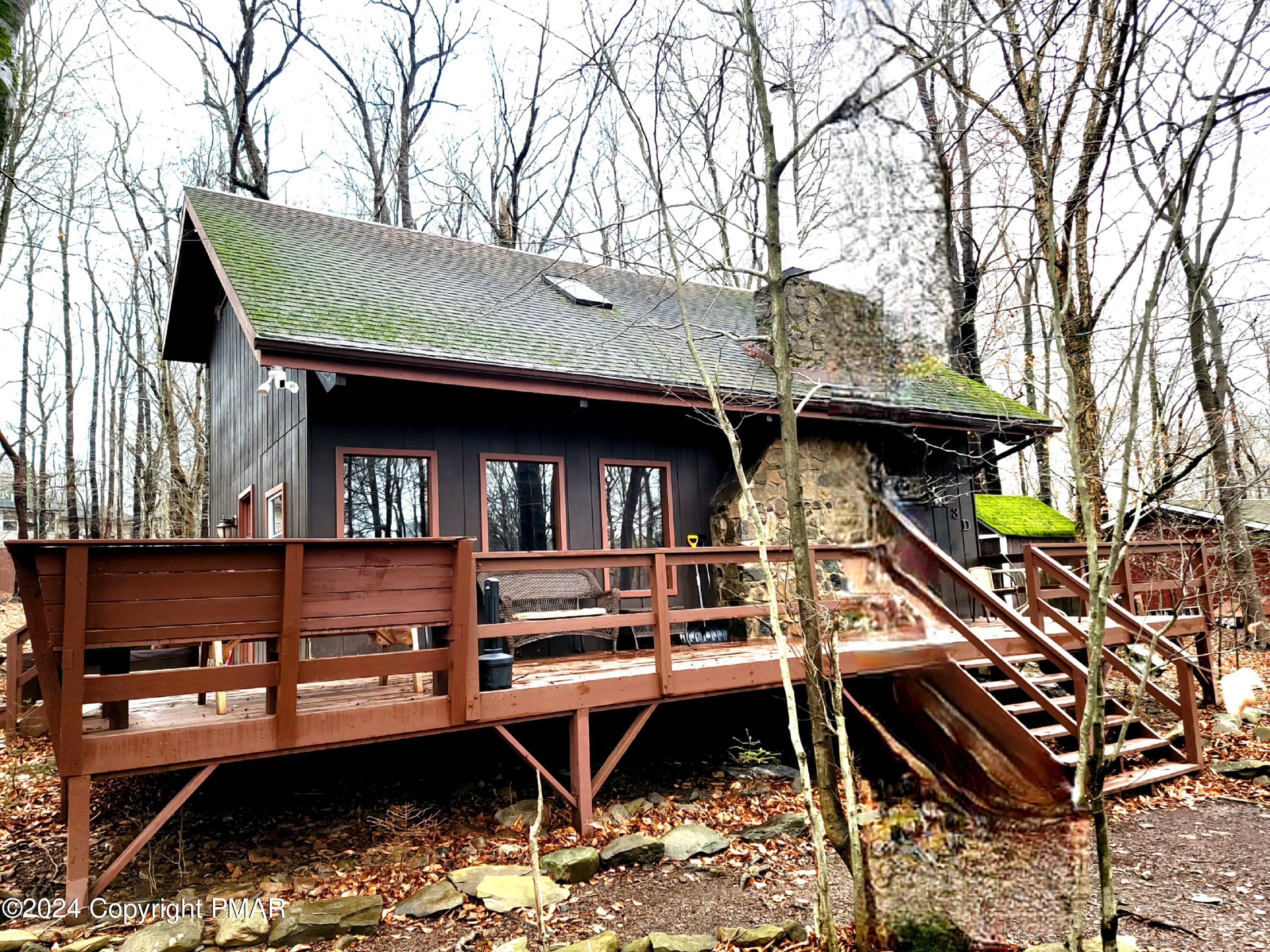 a backyard of a house with wooden stairs and table and chairs