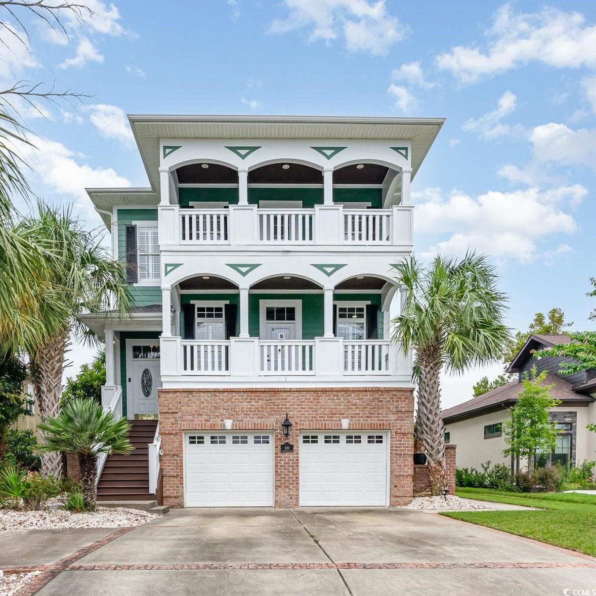 Raised beach house featuring a balcony and a garag