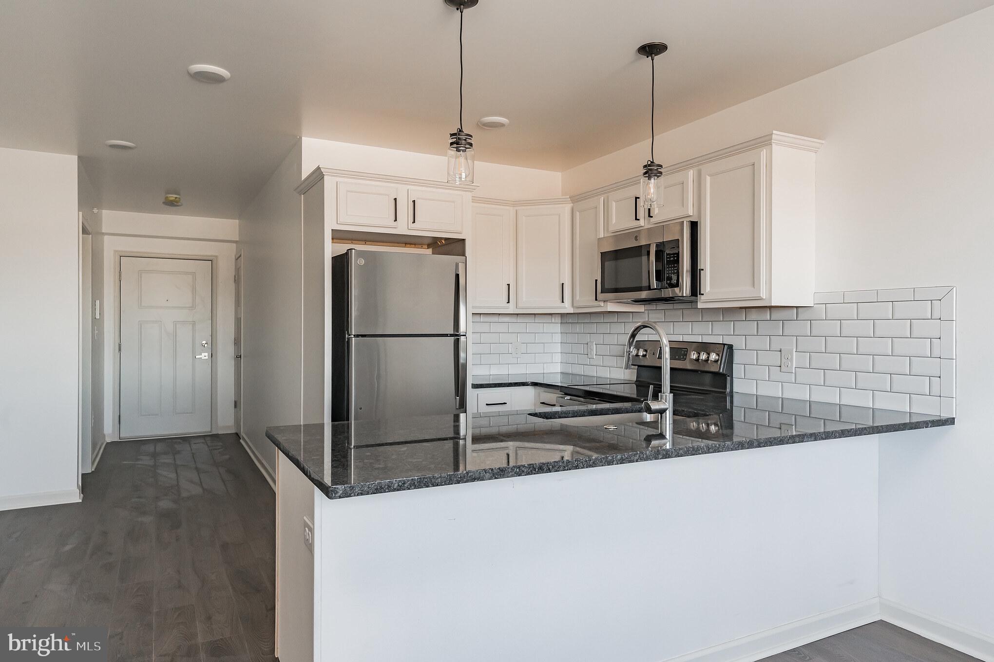 a kitchen with granite countertop a refrigerator and a sink