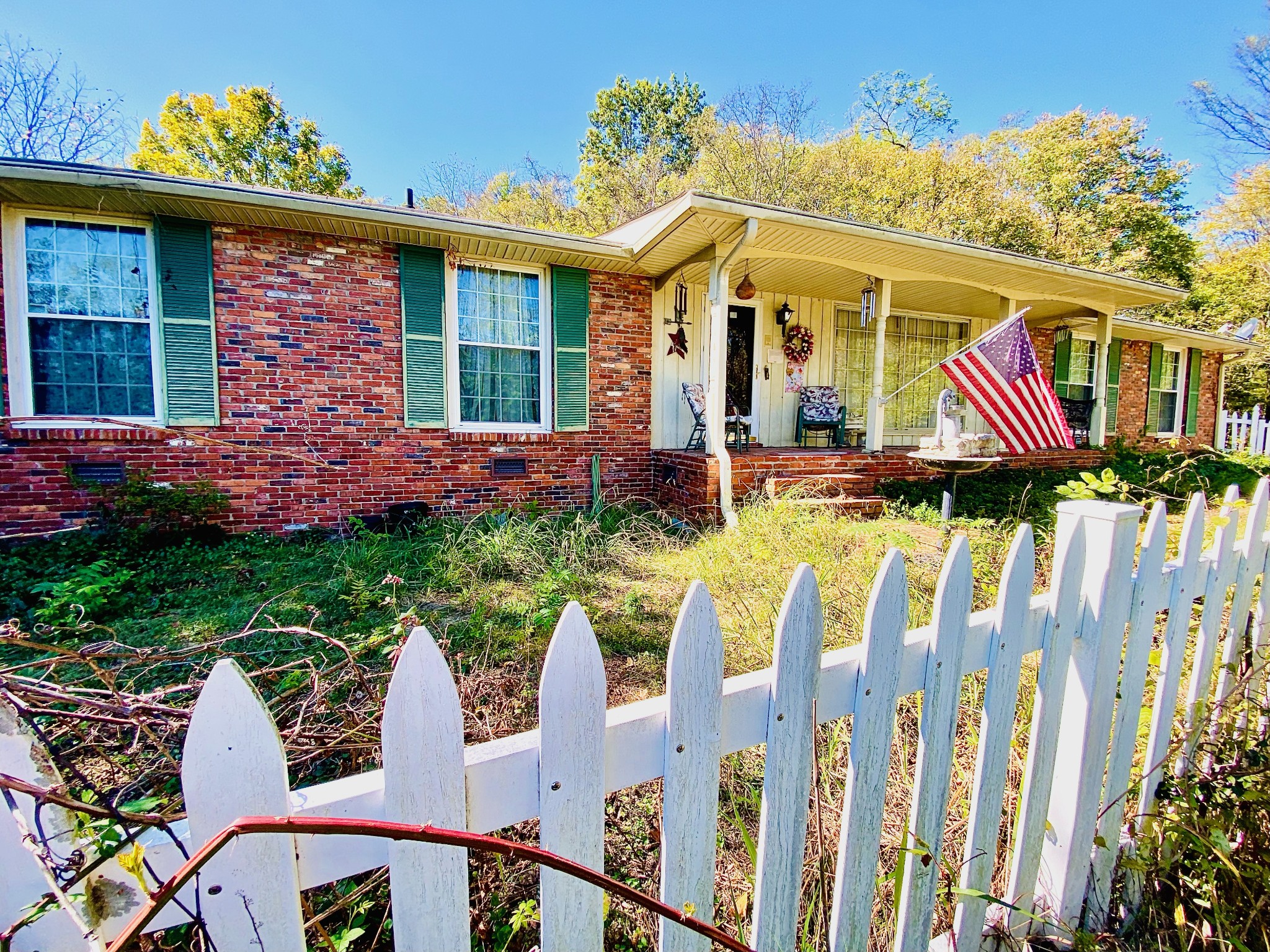 a front view of house and yard with beautiful flowers