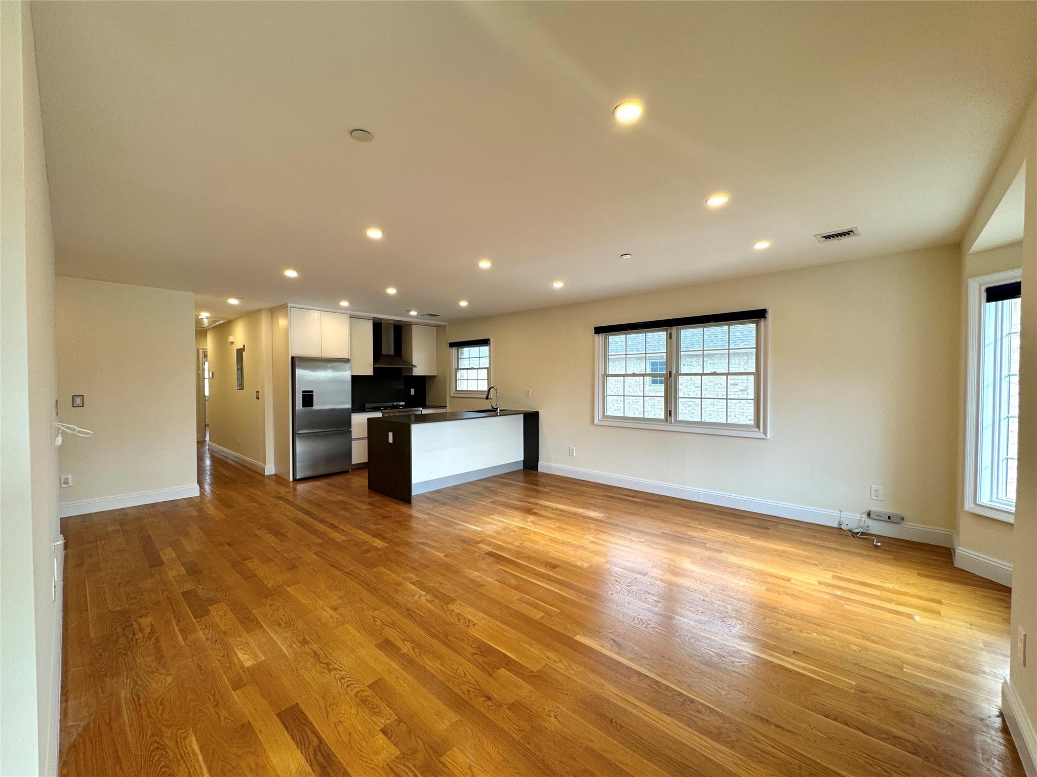 Unfurnished living room with light wood-type flooring and sink