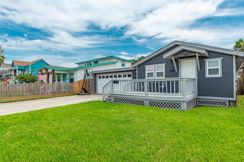 Welcome to 5819 Avenue R this single-story home featuring a white-trimmed front deck, an attached garage, and a well-maintained lawn. 