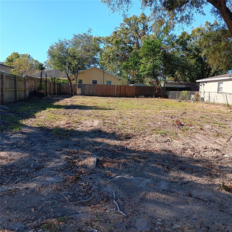 a view of a yard with wooden fence