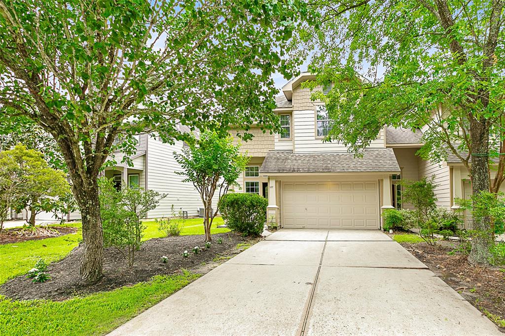 a front view of a house with a yard and trees