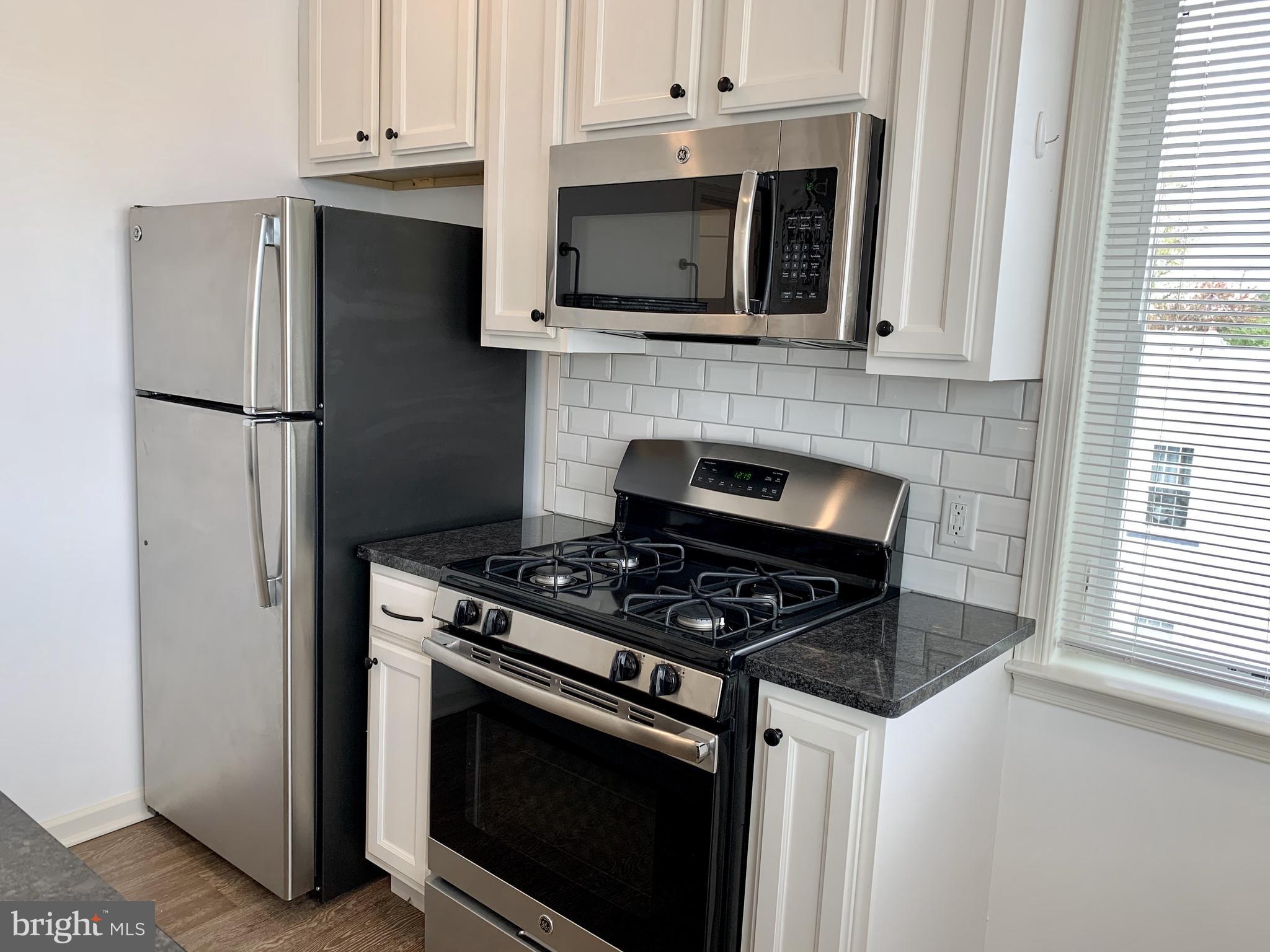 a kitchen with stainless steel appliances a stove a microwave and a refrigerator