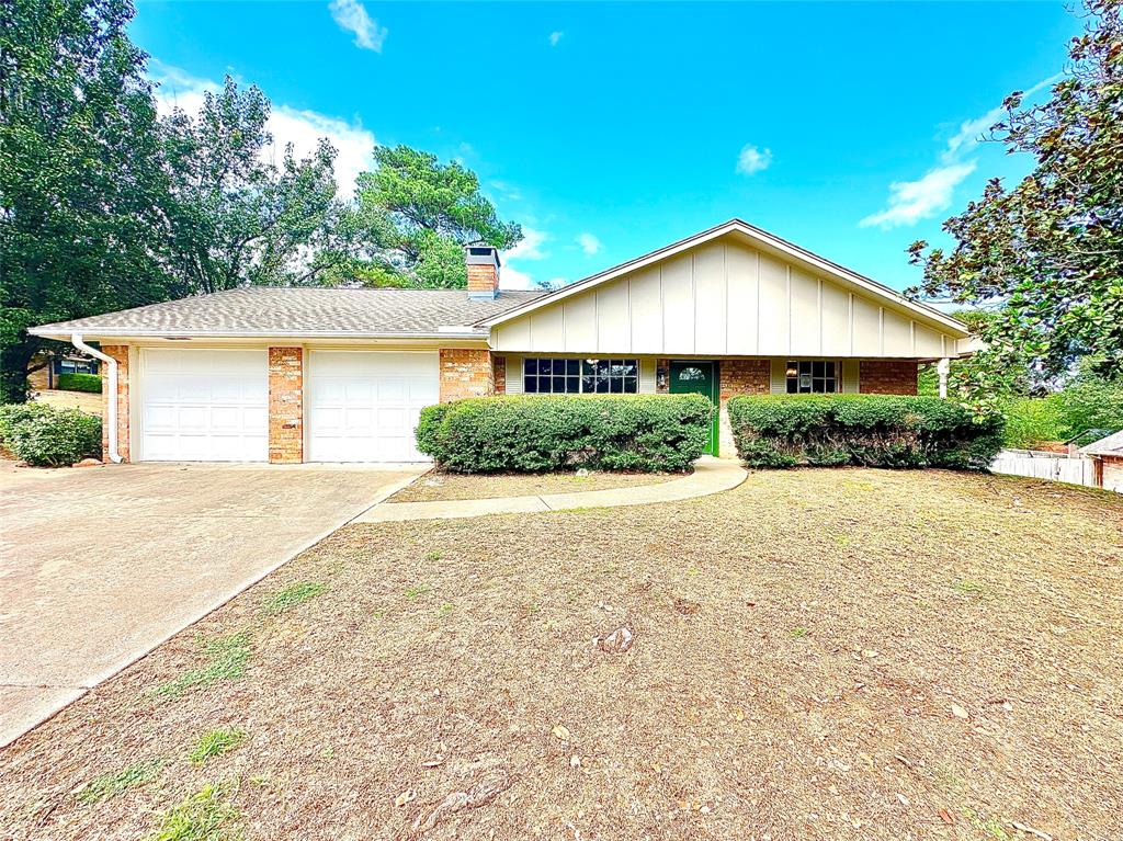 a house with a yard plants and large tree