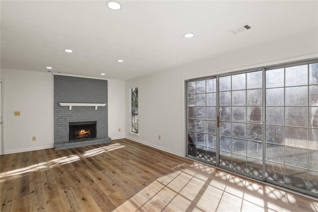 a view of wooden floor fire place and window in a room