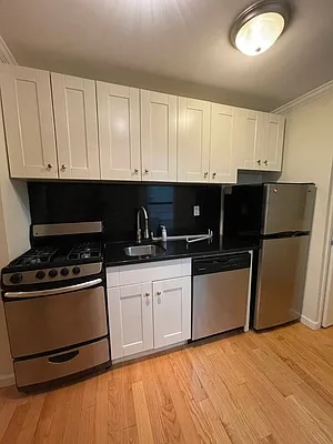 a kitchen with granite countertop a stove a sink dishwasher and a refrigerator