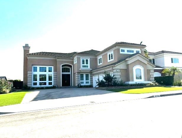 a front view of a house with a garden and lake view