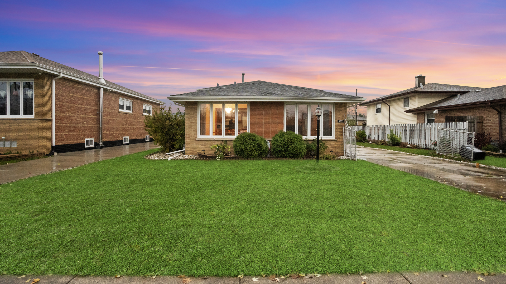 a front view of a house with a yard and trees