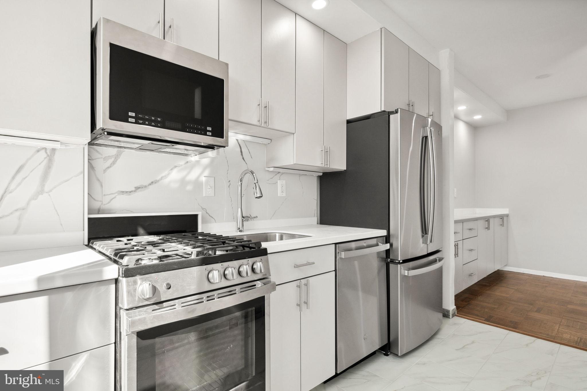 a kitchen with appliances a counter space and cabinets