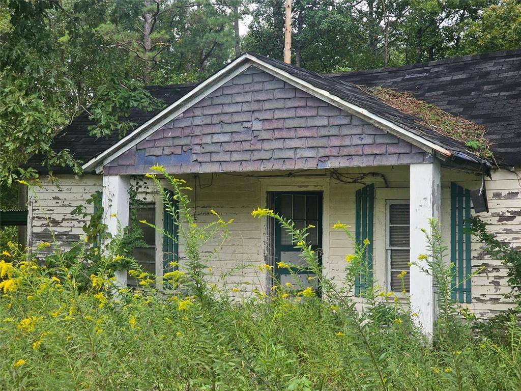 a view of a house with potted plants and a table and chairs