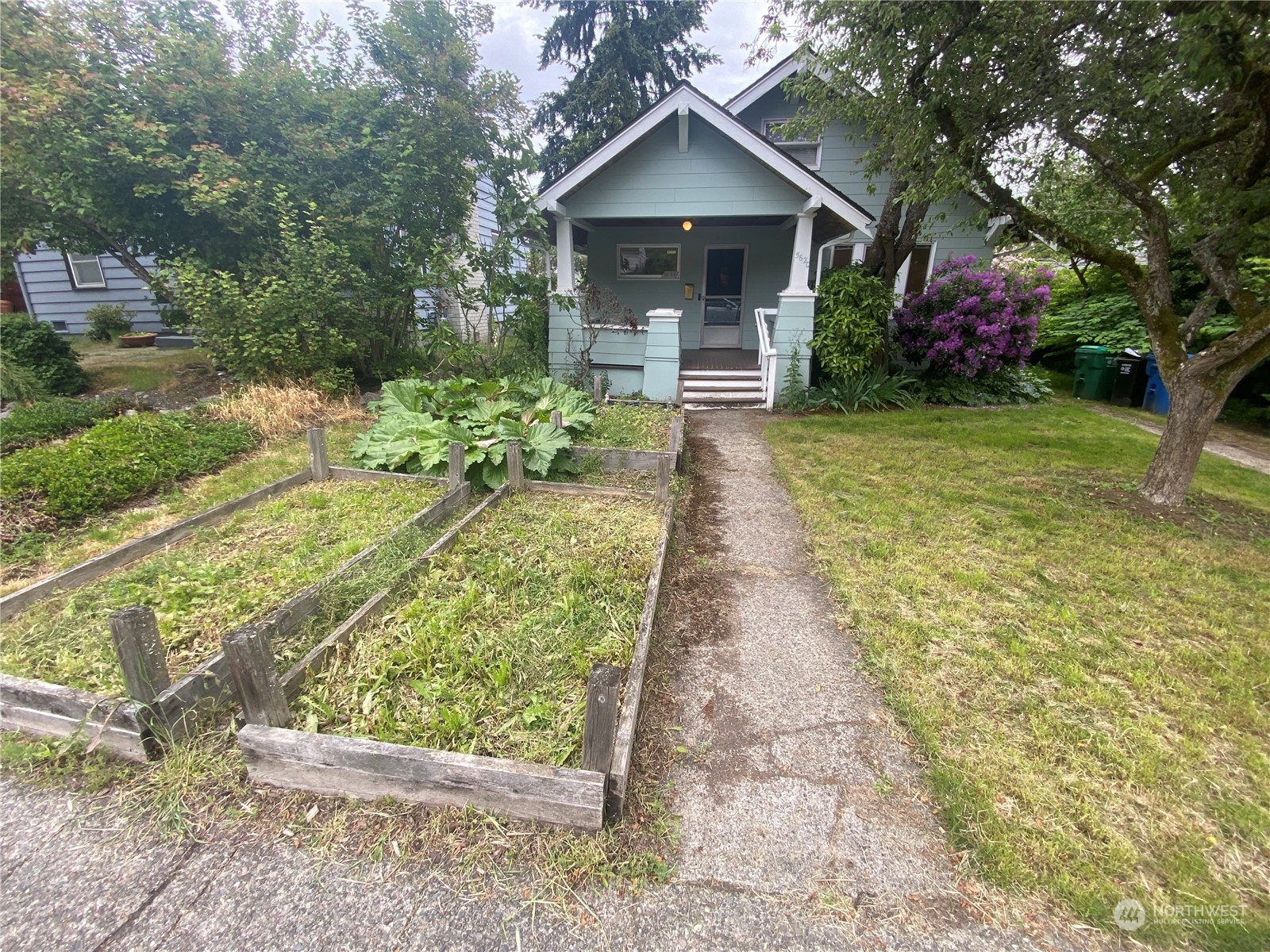 a front view of a house with a yard and trees