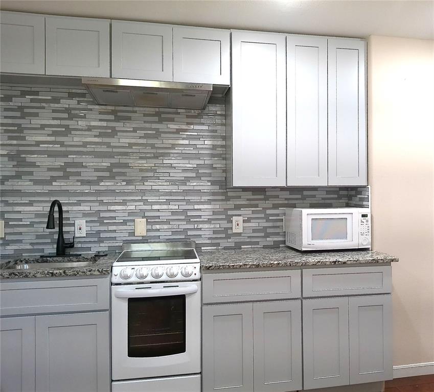 a kitchen with stainless steel appliances granite countertop white cabinets and a stove