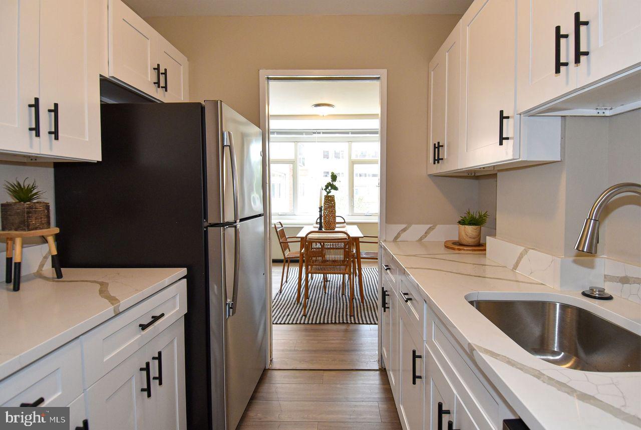 a kitchen with a refrigerator sink and white cabinets