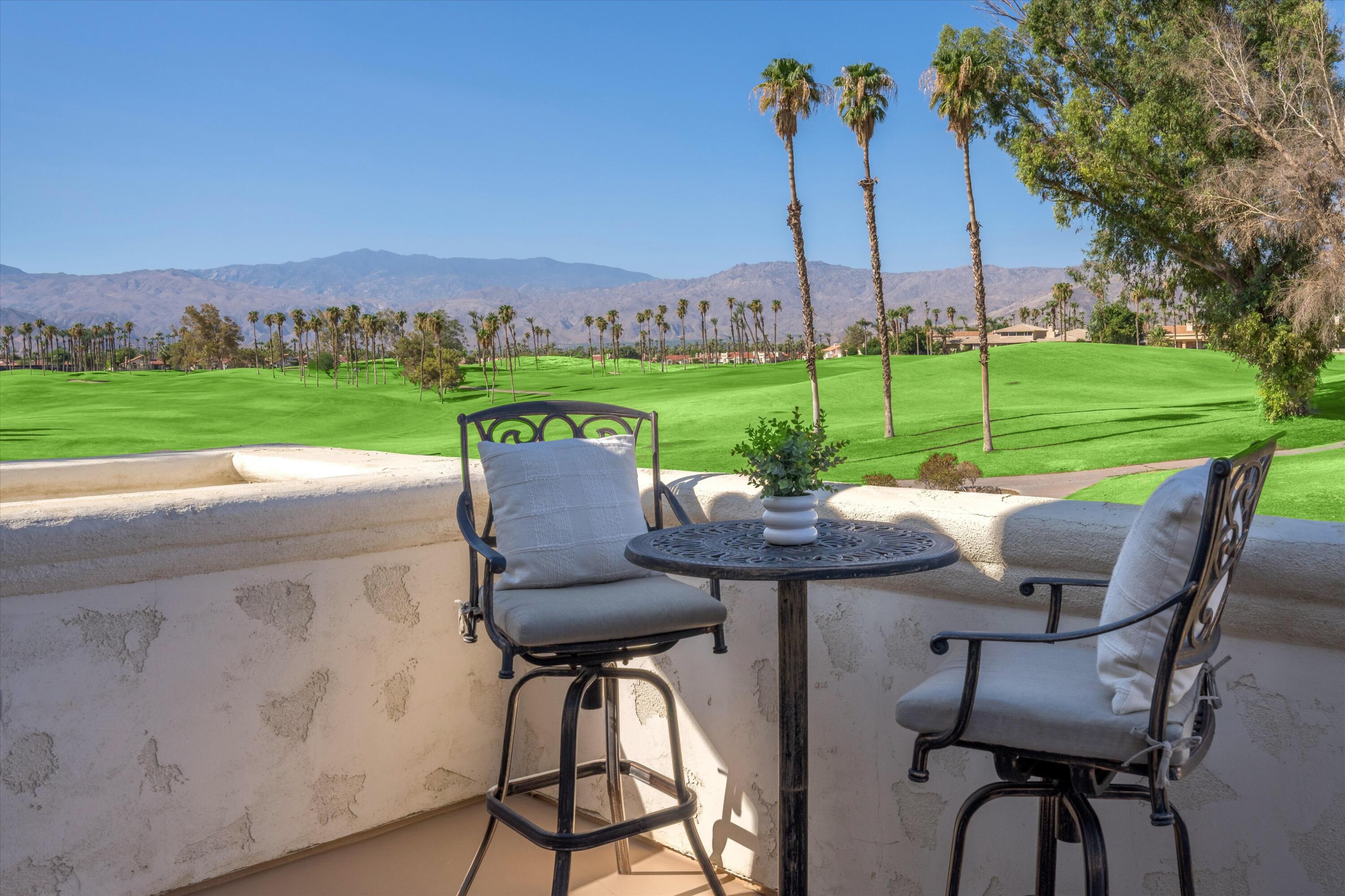 a view of a patio with table and chairs potted plants and palm trees