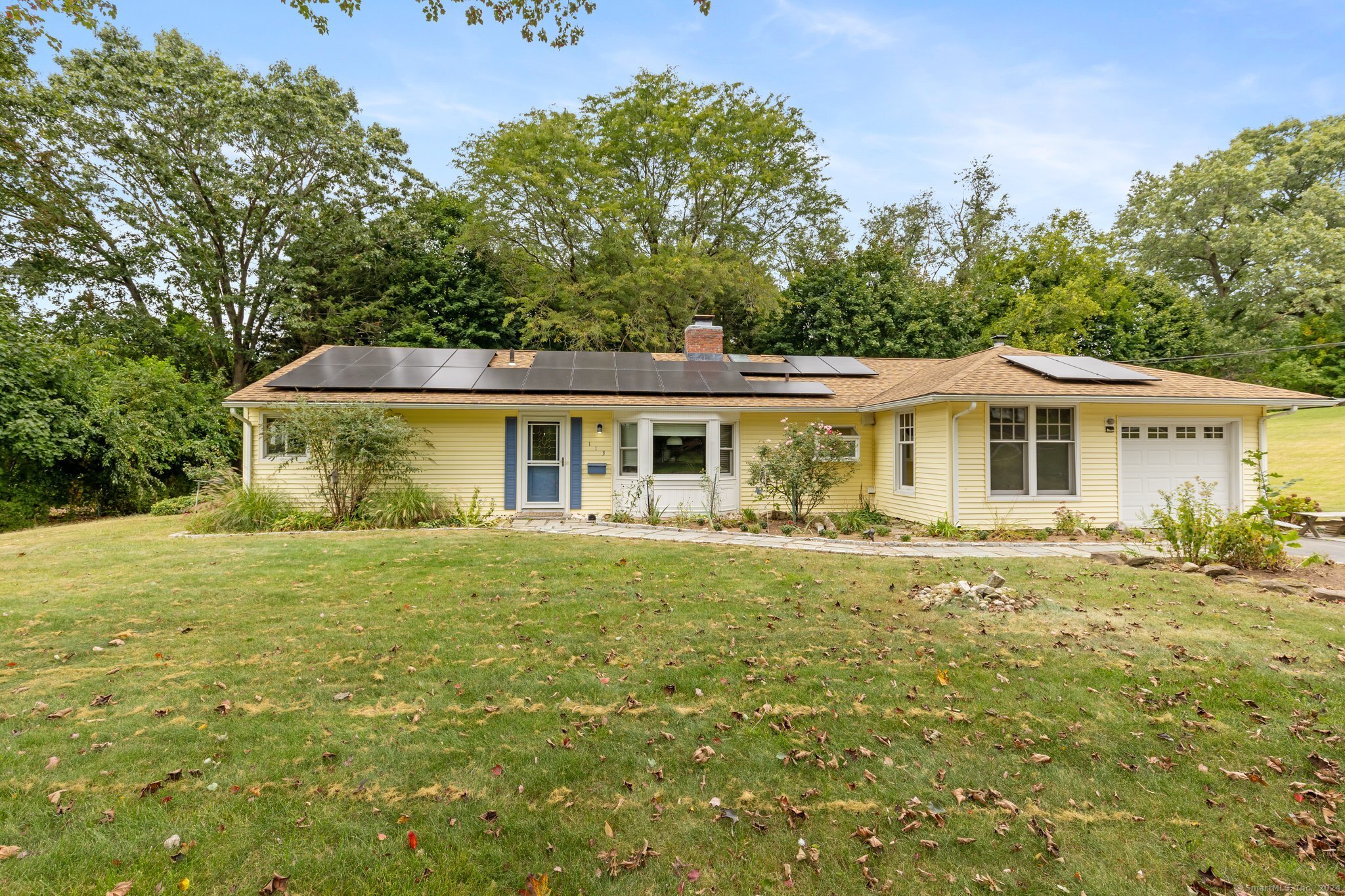 a front view of house with yard seating and green space