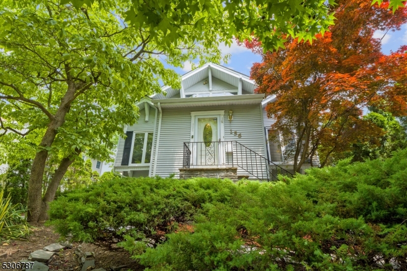 a front view of a house with yard and trees