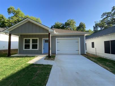 a view of a house with yard and tree in front of it