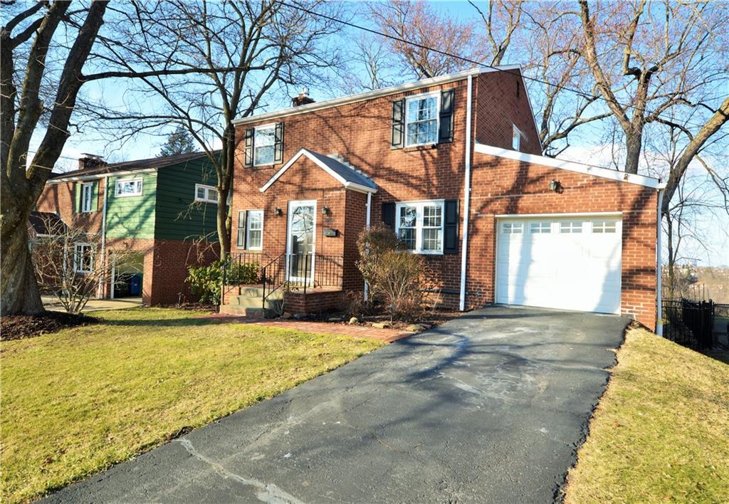 a view of a house with a large tree in front of it