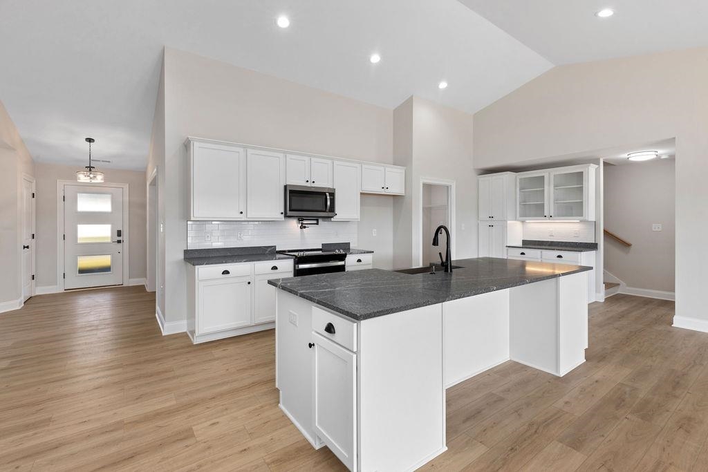 a kitchen with stainless steel appliances kitchen island granite countertop a sink and cabinets