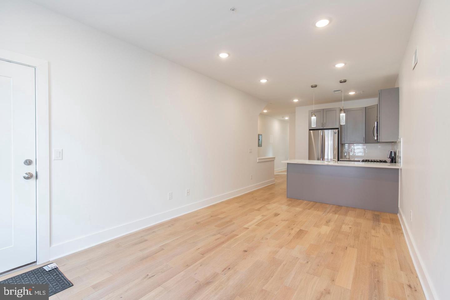 a view of kitchen with kitchen island wooden floor center island and stainless steel appliances