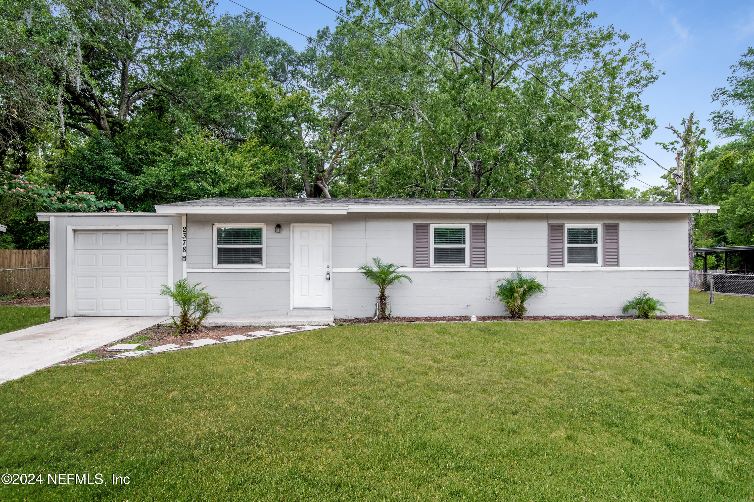 a view of a house with a backyard and a tree