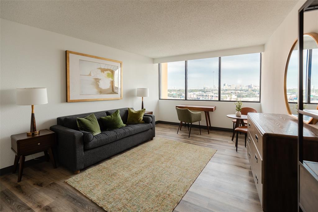 a living room with furniture a large window and a table