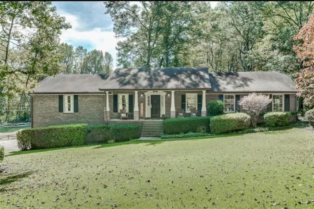 a front view of a house with a yard and trees