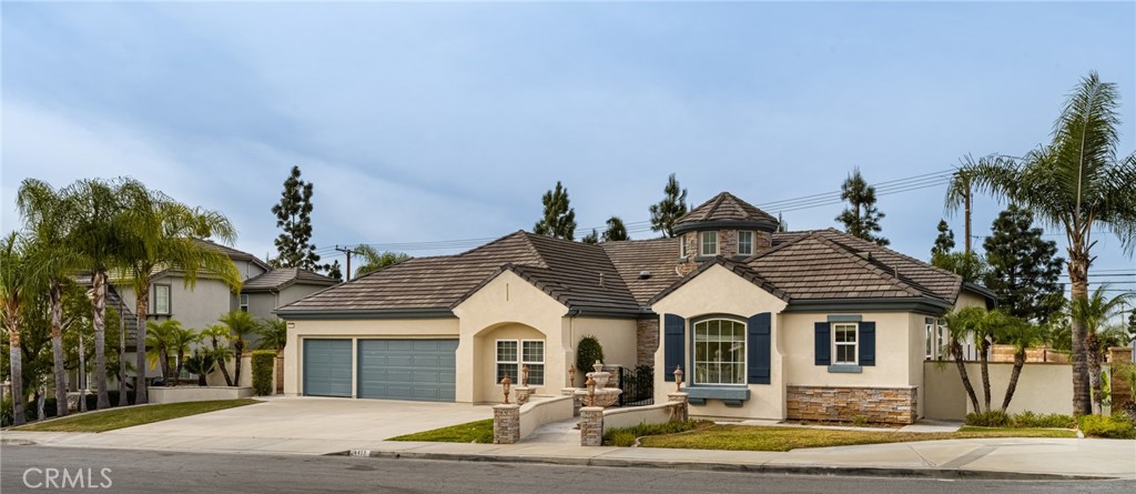 a view of a house with a yard and palm trees