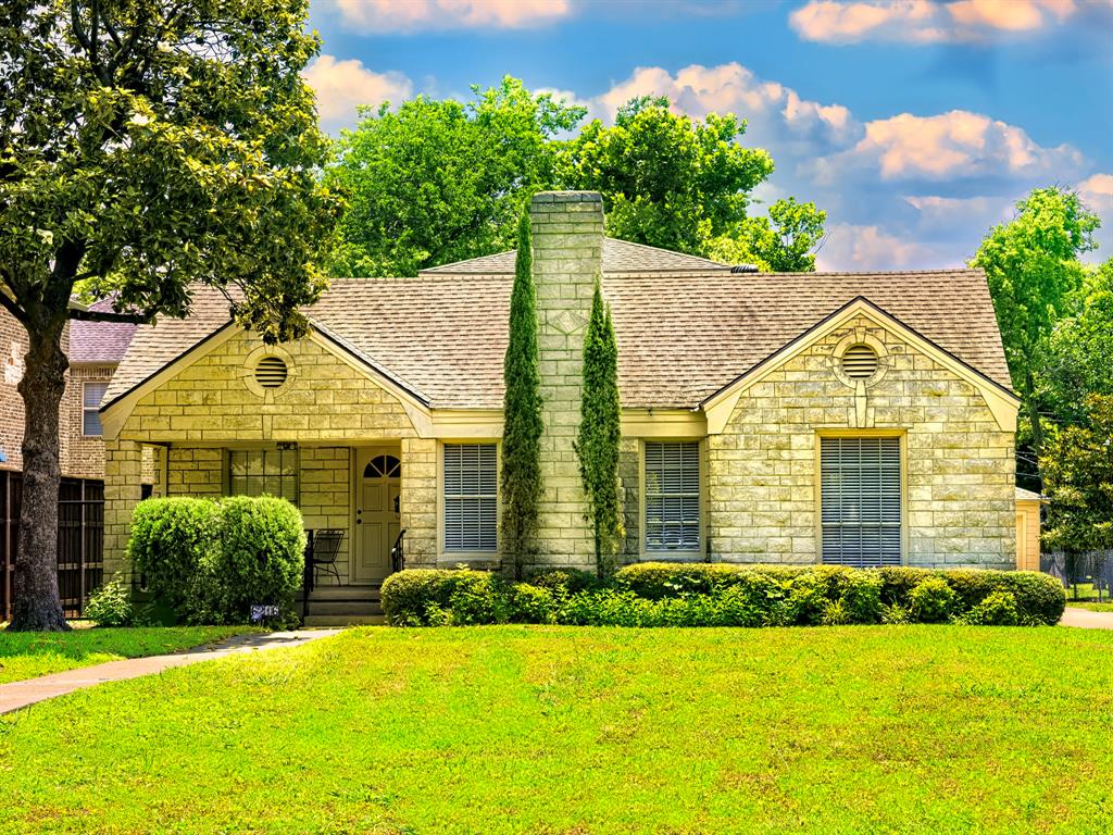 a front view of a house with a yard and trees