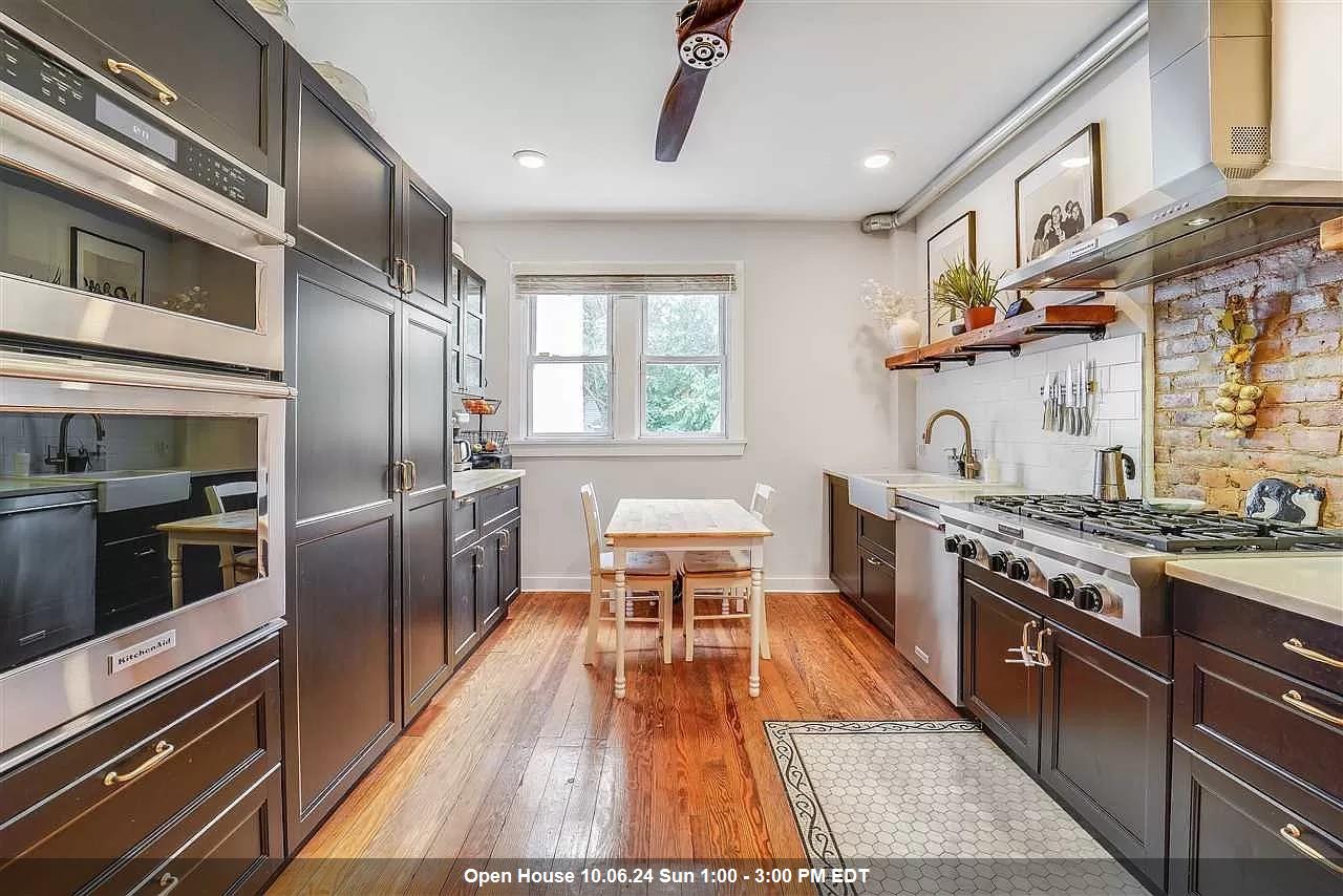 a kitchen with stainless steel appliances granite countertop a stove top oven a sink with wooden floors