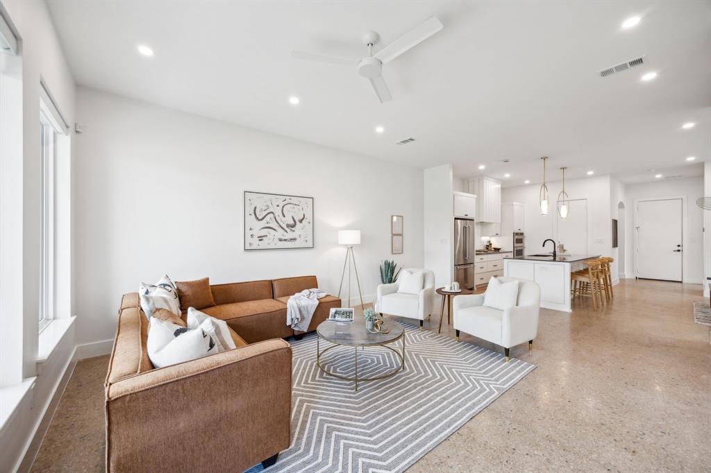 a living room with furniture and a view of kitchen