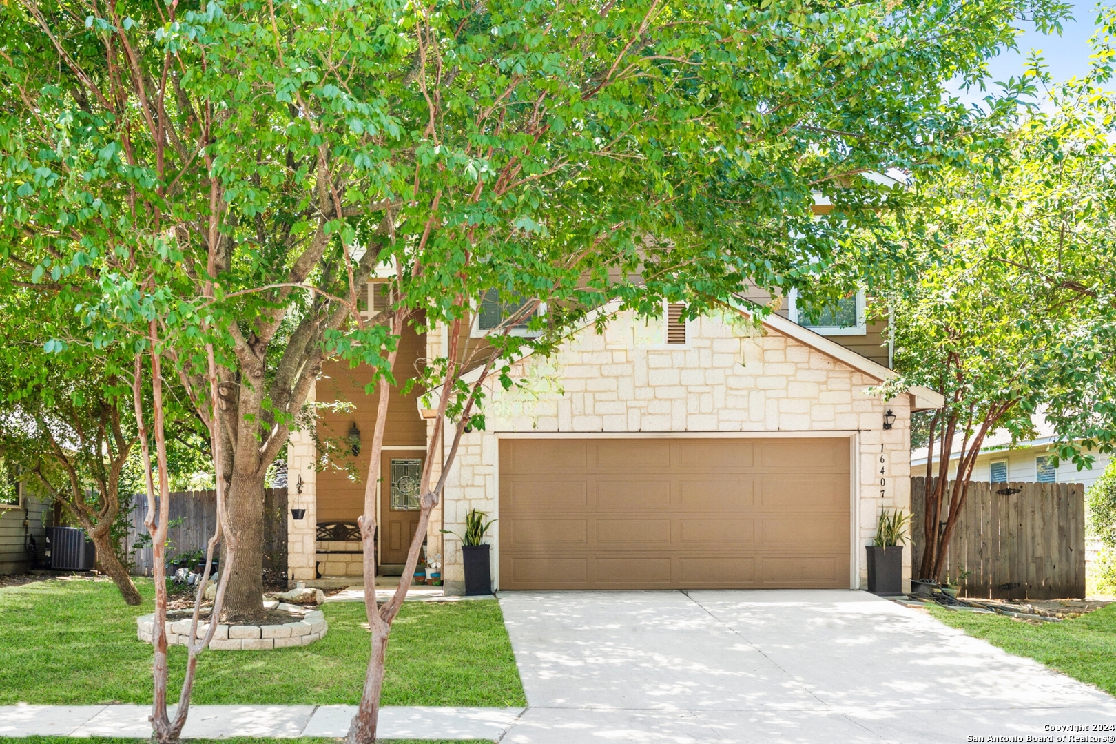 a front view of a house with a yard and tree