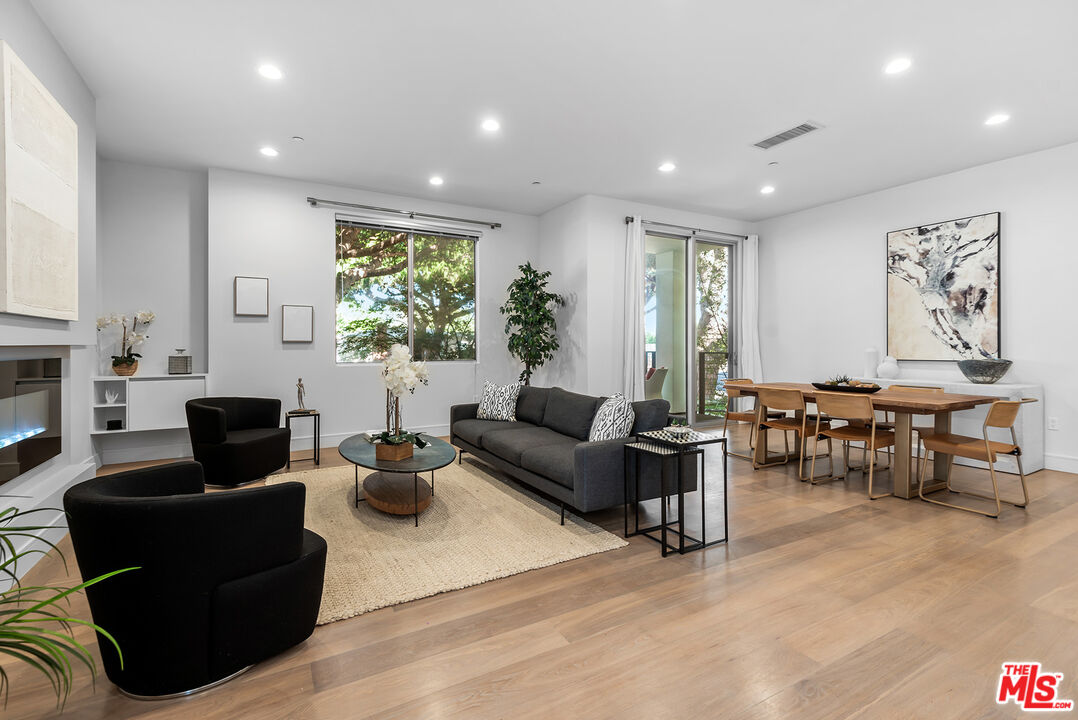 a living room with furniture potted plant and a large window