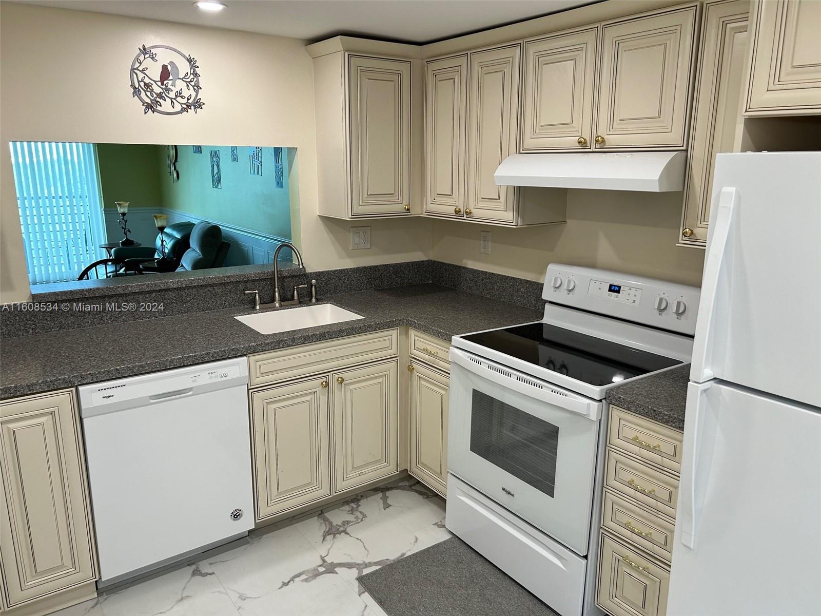 a kitchen with white cabinets and white appliances