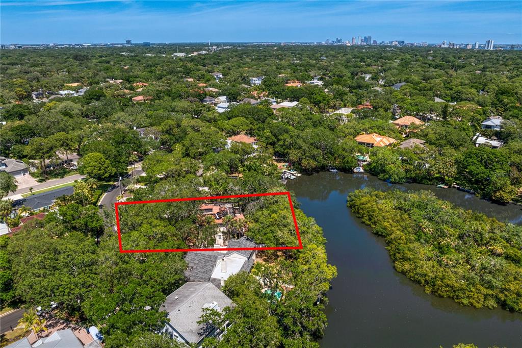 an aerial view of a houses with a yard and lake view