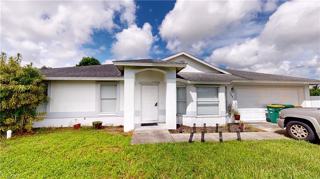 Ranch-style home with a garage and a front lawn