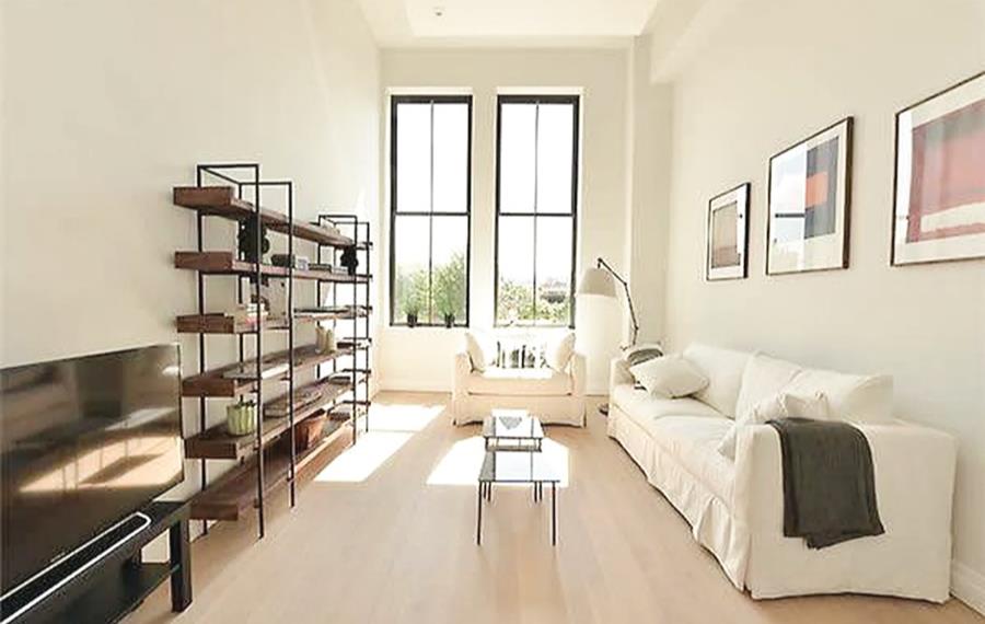 a living room with furniture and a floor to ceiling window