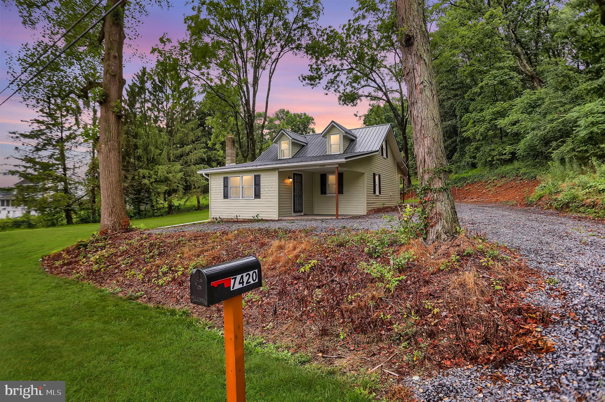 a view of a house with backyard and tree