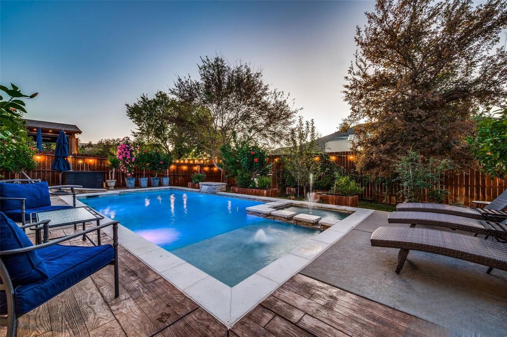 a view of swimming pool with chairs and wooden fence