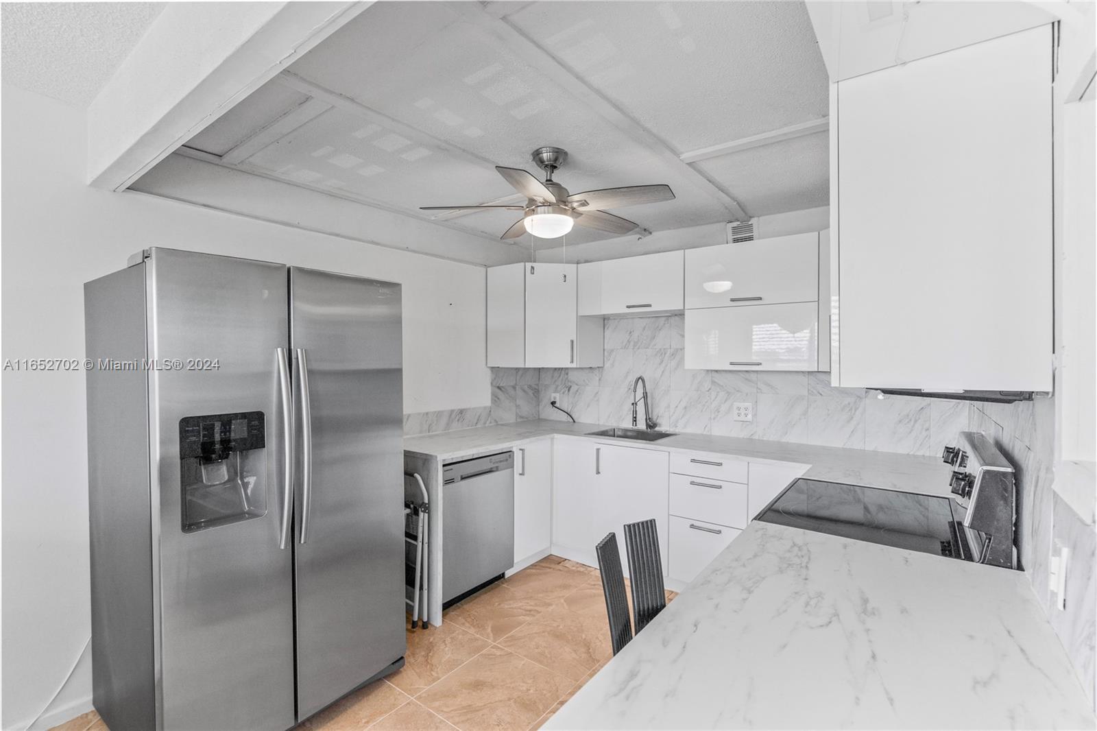 a kitchen with a refrigerator sink and cabinets